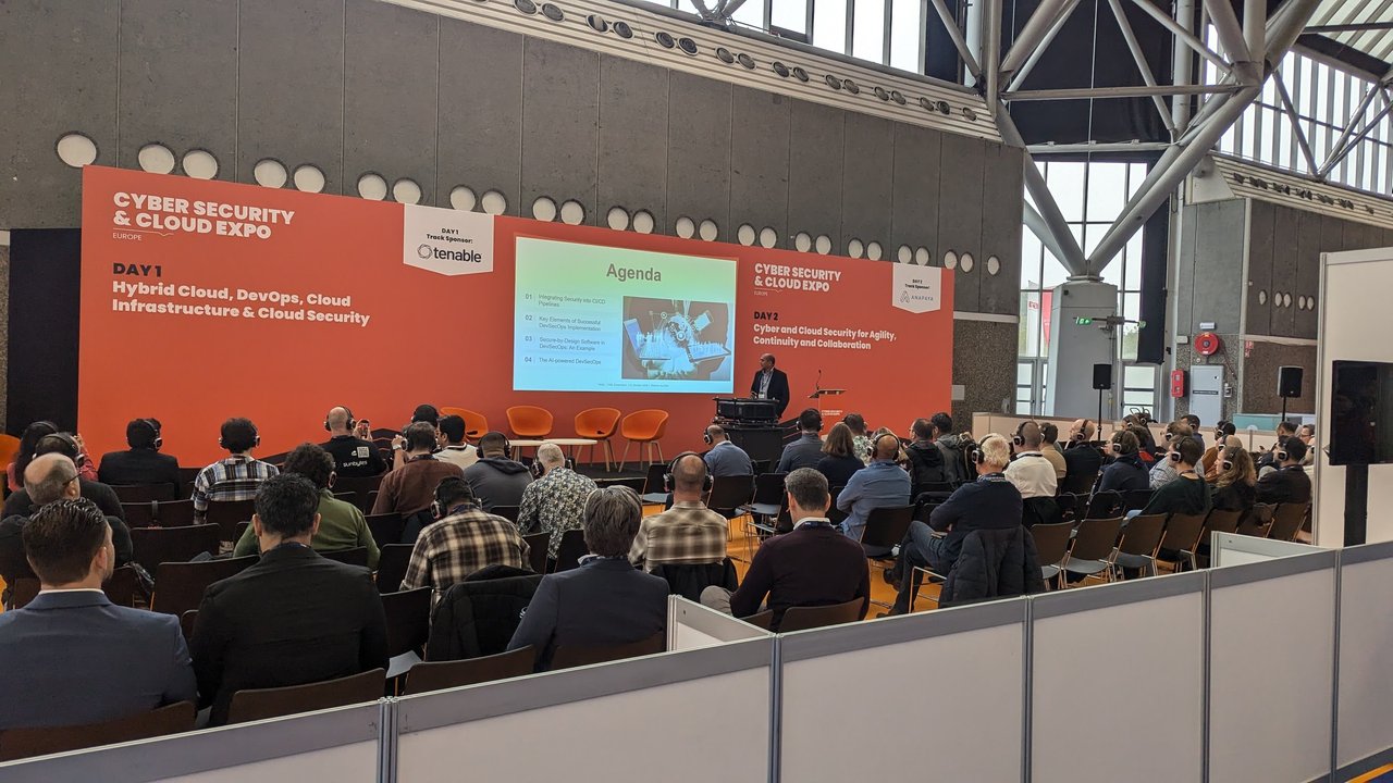 The Cyber Security & Cloud Expo stage at the RAI with an audience in headphones, Day 1 track Hybrid Cloud, DevOps, Cloud Infrastructure & Cloud Security