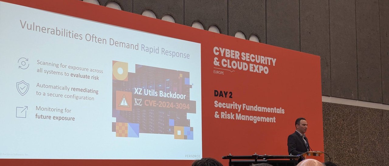 Slide: Vulnerabilities Often Demand Rapid Response, with the XZ Utils Backdoor CVE-2024-3094 graphic and the speaker at the lectern