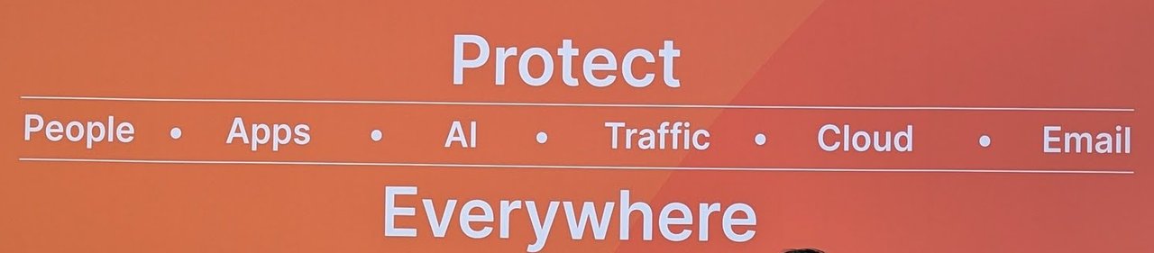 The Cloudflare booth wall reading Protect, People, Apps, AI, Traffic, Cloud, Email, Everywhere