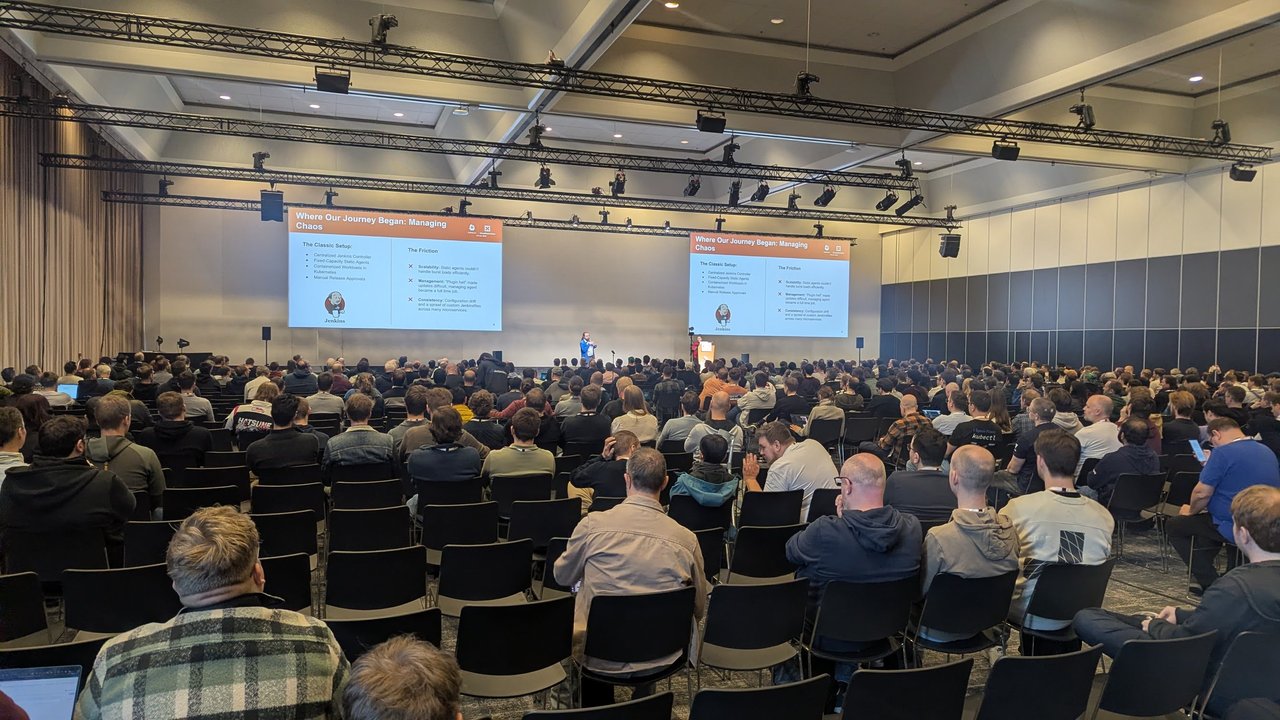 A packed KubeCon Europe 2026 breakout room with the slide Where Our Journey Began: Managing Chaos on both screens, listing a centralized Jenkins controller and static agents on one side and scalability, management and consistency problems on the other