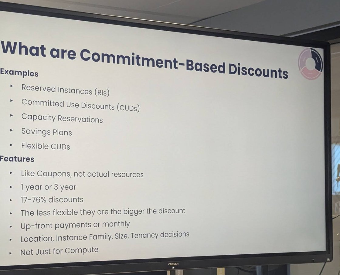 Slide titled What are Commitment-Based Discounts, with examples such as reserved instances and savings plans, and features such as one or three year terms and 17-76% discounts