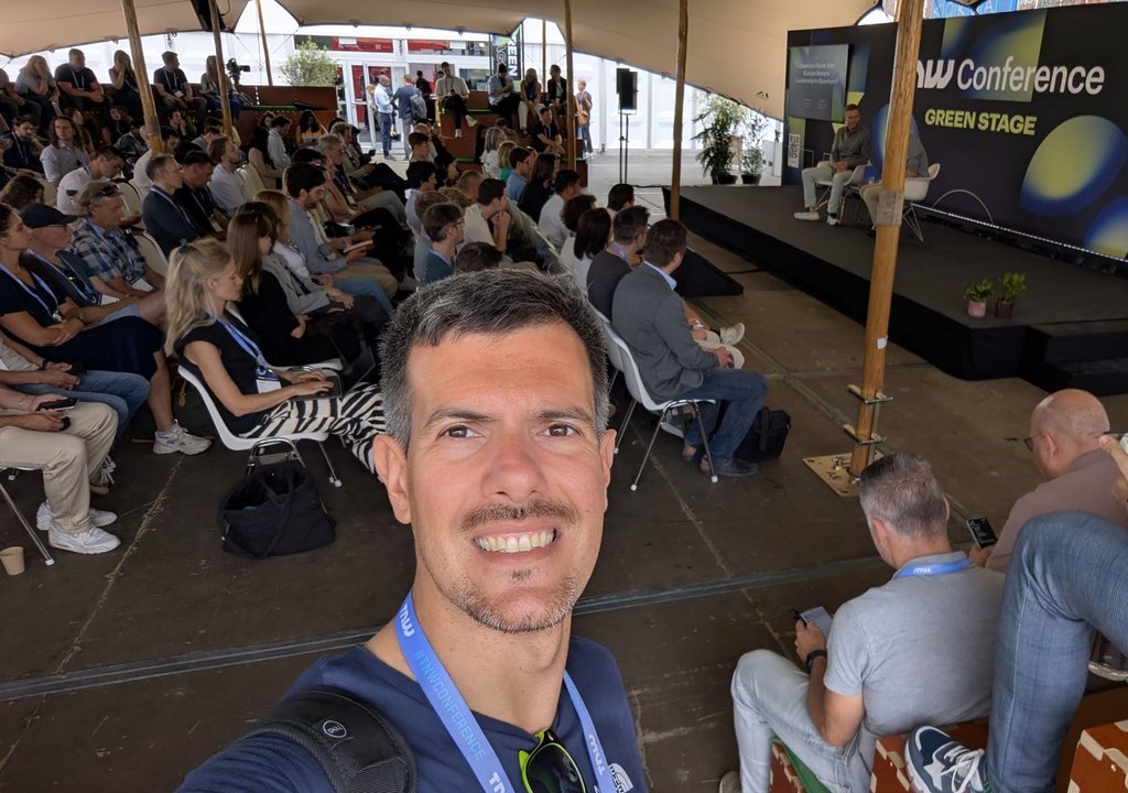Packed seating in front of the TNW Conference Green Stage, with the stage sign and a programme board behind