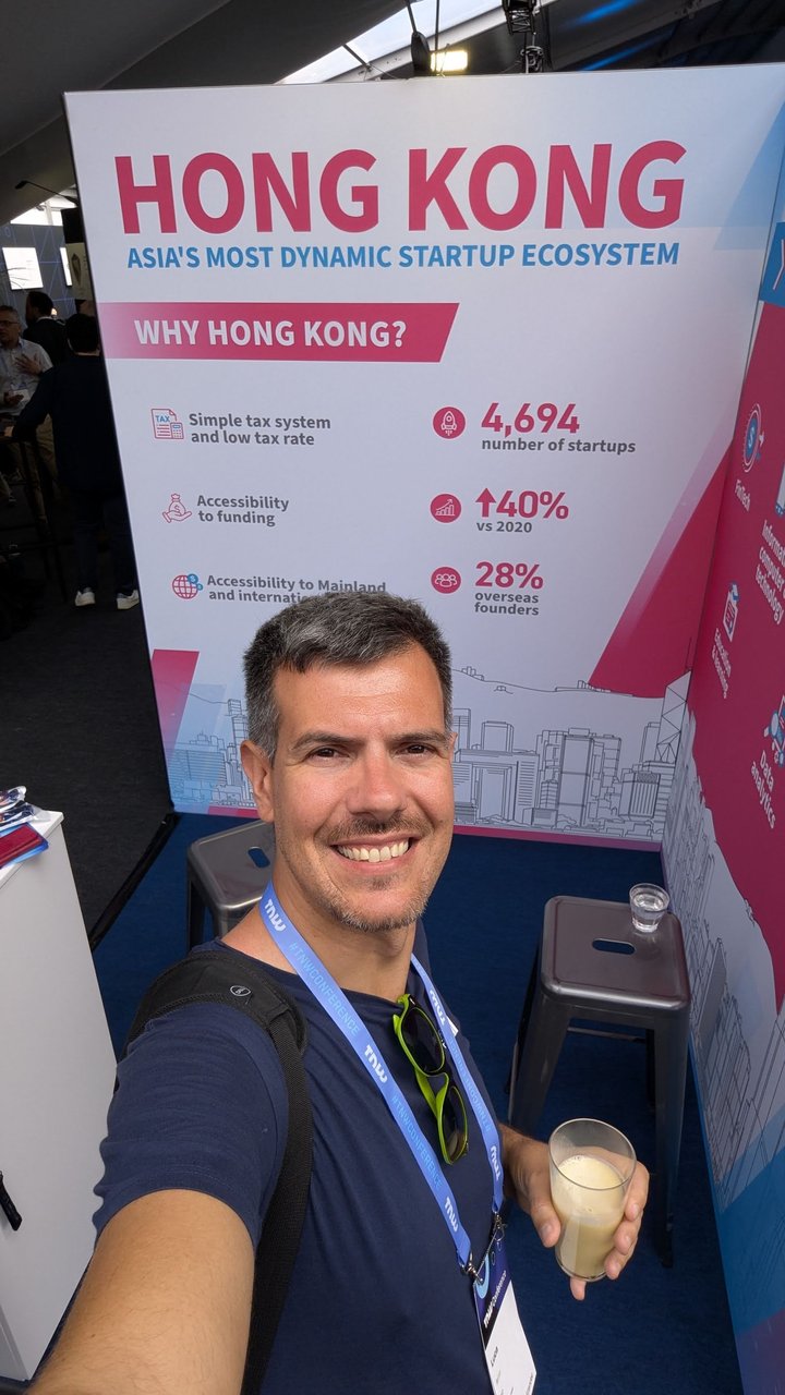 Luca Berton at the Hong Kong pavilion in front of a Why Hong Kong board with startup statistics