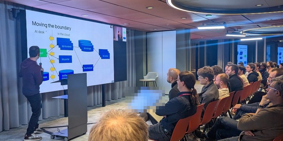 Ed Schouten in front of the Moving the boundary slide, where yellow arrows push the line between at desk and in the cloud towards the developer's machine