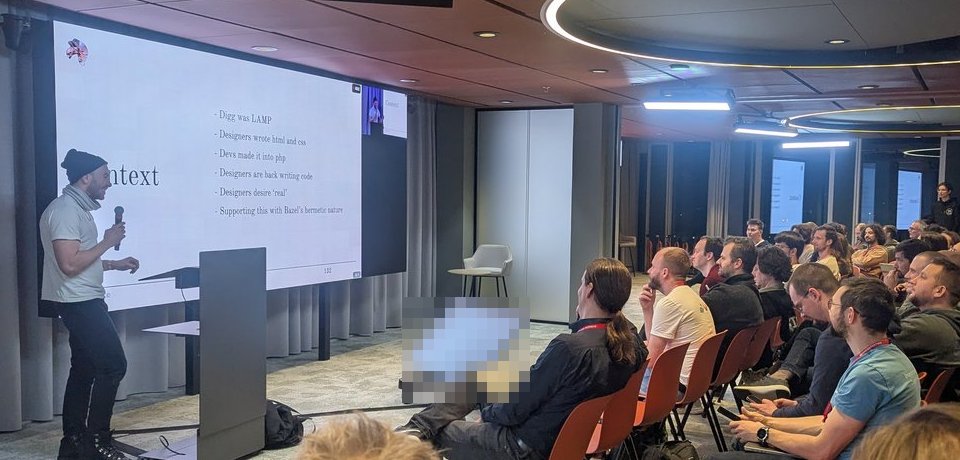 Jeff Hodsdon presenting the Context slide: Digg was LAMP, designers wrote HTML and CSS, devs made it into PHP, designers are back writing code, supporting this with Bazel's hermetic nature