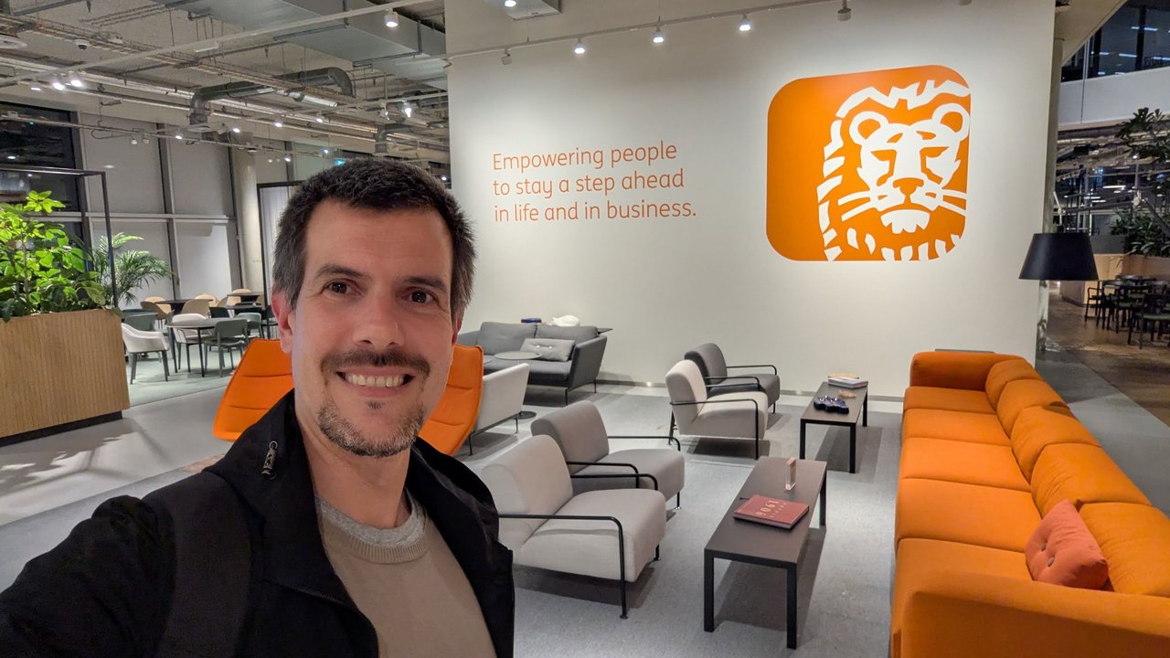 Selfie of Luca Berton in the ING lounge in Amsterdam, in front of the orange ING lion logo and the line Empowering people to stay a step ahead in life and in business