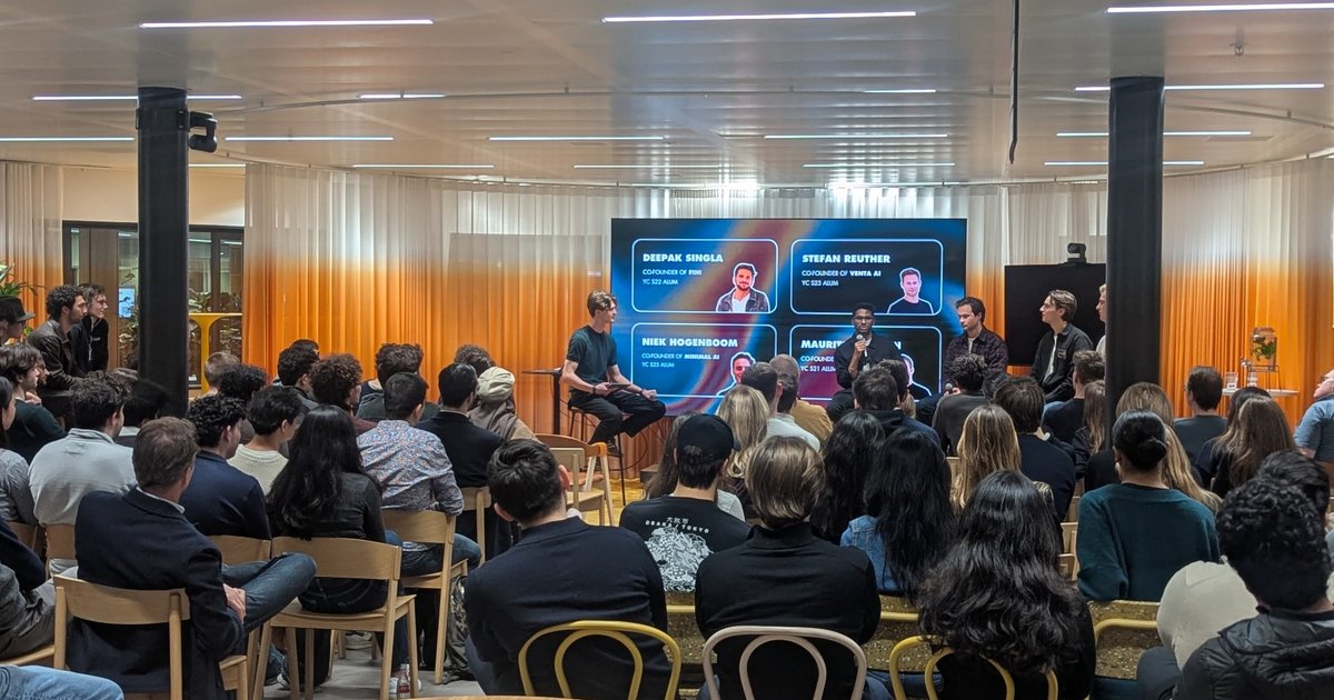 Founder panel on stage at Beyond the Batch in Amsterdam, with a slide listing the YC alumni on the panel and a full audience in front