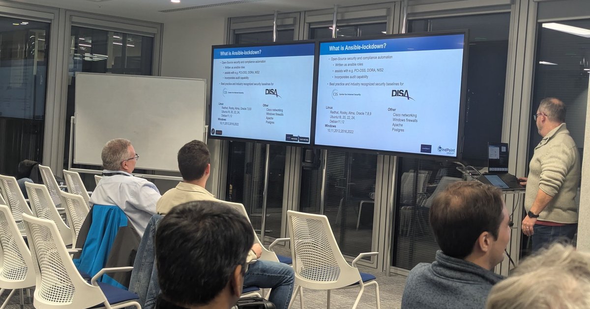 The 'What is Ansible-lockdown?' slide listing CIS and DISA baselines on two screens at the Ansible London meetup, November 2024