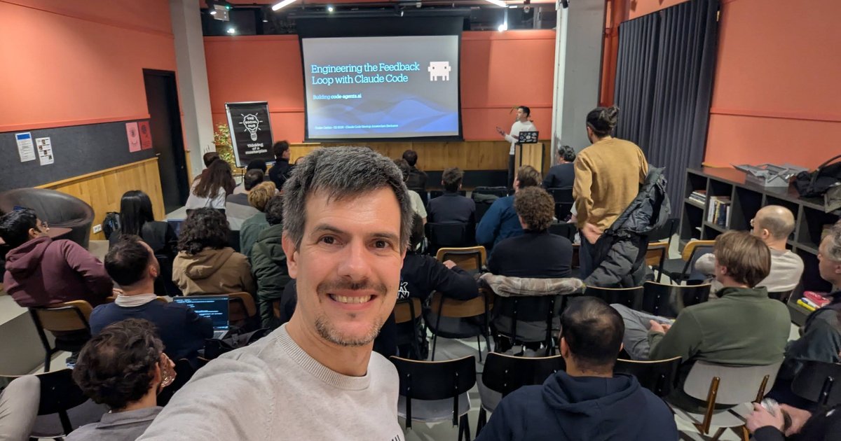 Luca Berton at Claude Code Meetup Amsterdam with the Engineering the Feedback Loop with Claude Code title slide behind him