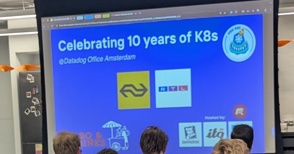 A Celebrating 10 years of K8s slide on the screen in a meetup room at the Datadog office in Amsterdam