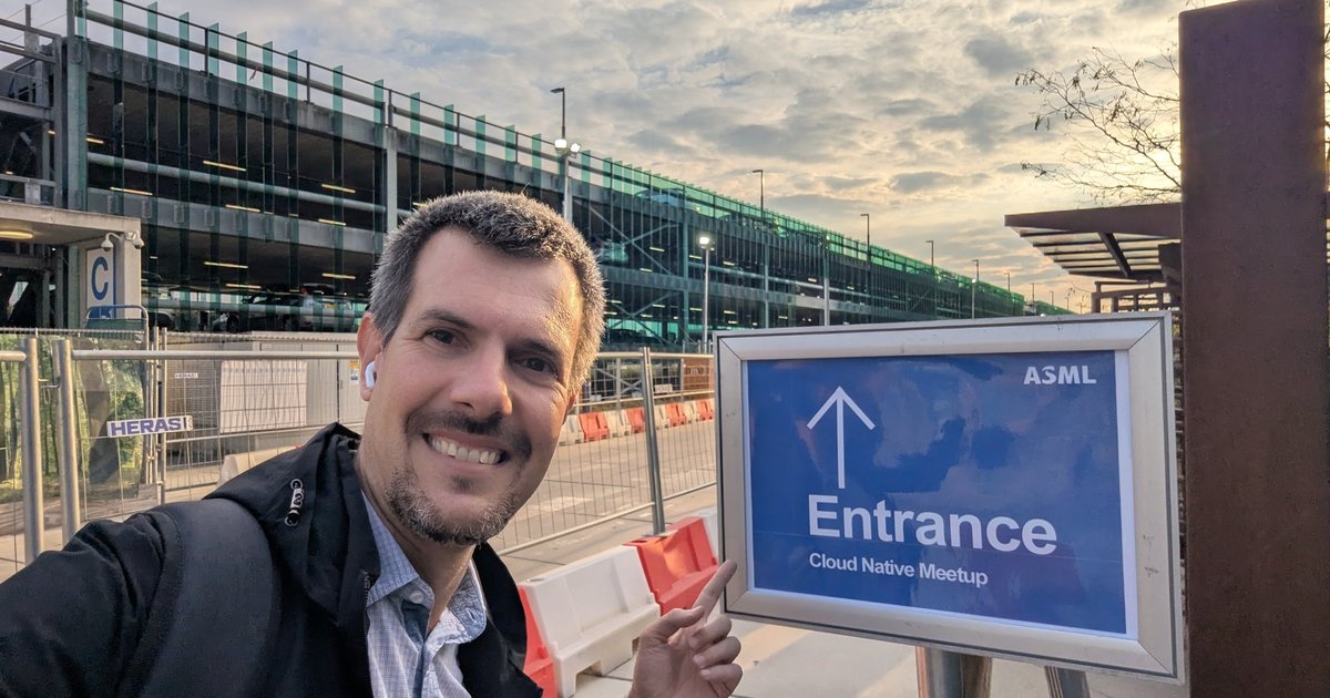 Luca Berton pointing at the ASML Entrance sign for the Cloud Native Meetup in Veldhoven