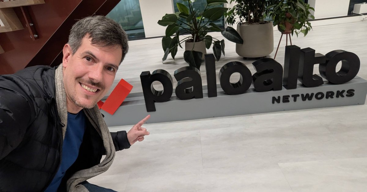 Luca Berton pointing at the Palo Alto Networks logo sign in the Amsterdam office after the Dutch Kubernetes meetup
