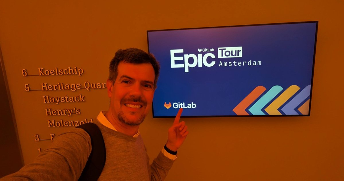 Luca Berton pointing at a GitLab Epic Tour Amsterdam screen next to the Heineken Experience room directory