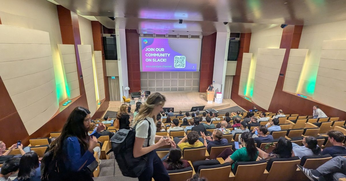 The lecture hall at the MLOps Community AI Agent World Tour in Amsterdam before the talks, with a Join our community on Slack slide on screen