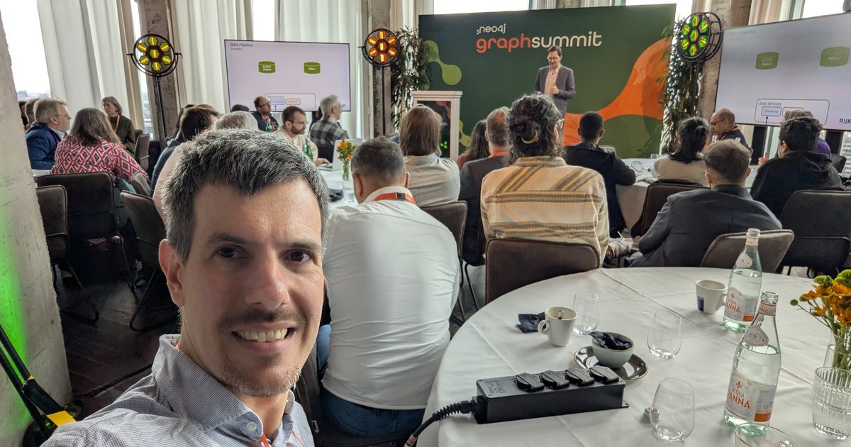 Luca Berton at Neo4j GraphSummit Amsterdam 2025 in A'DAM Tower, with the GraphSummit stage behind him