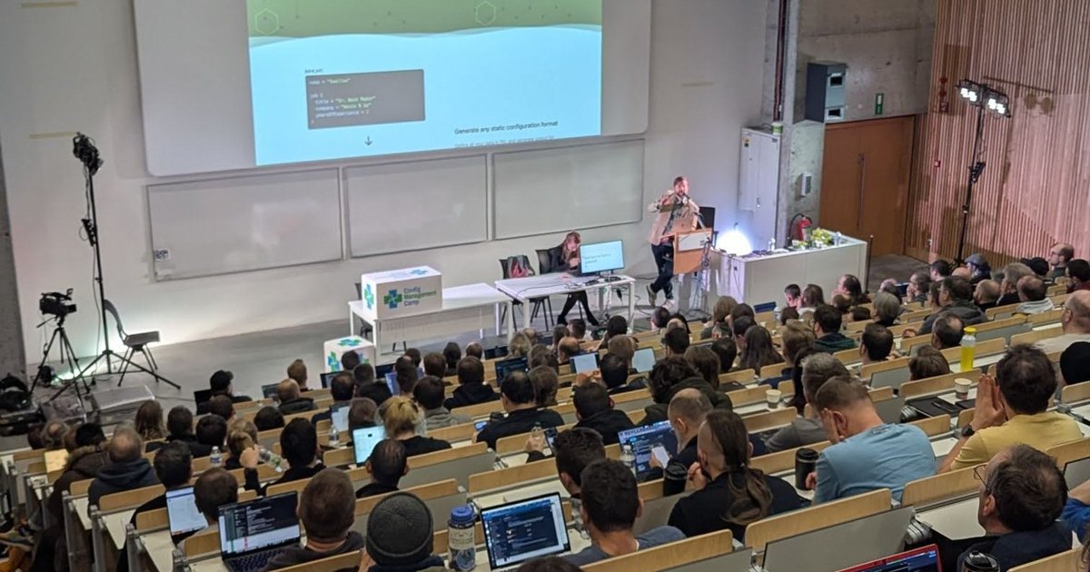A full auditorium at CfgMgmtCamp 2025 in Ghent during the Pkl talk, with a Pkl code sample on the projector