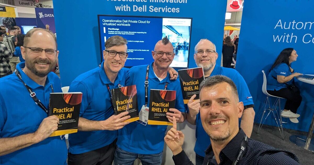 Dell Services team holding four copies of Practical RHEL AI at Red Hat Summit 2026