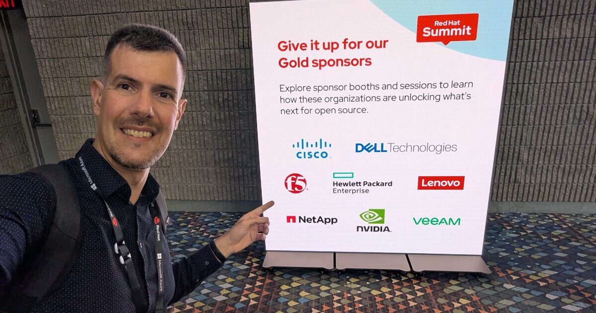 Luca Berton at Red Hat Summit 2026 in Atlanta pointing at Gold Sponsors board