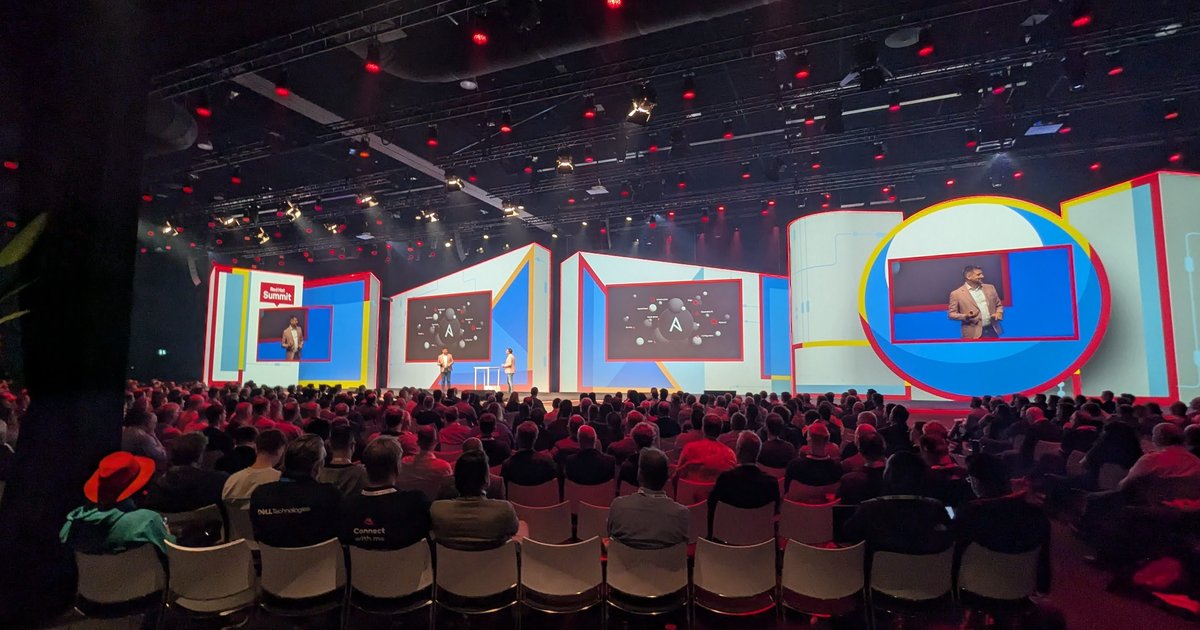 The main theatre at Red Hat Summit Connect Utrecht 2024, with a full audience facing a stage showing the Ansible logo on its screens