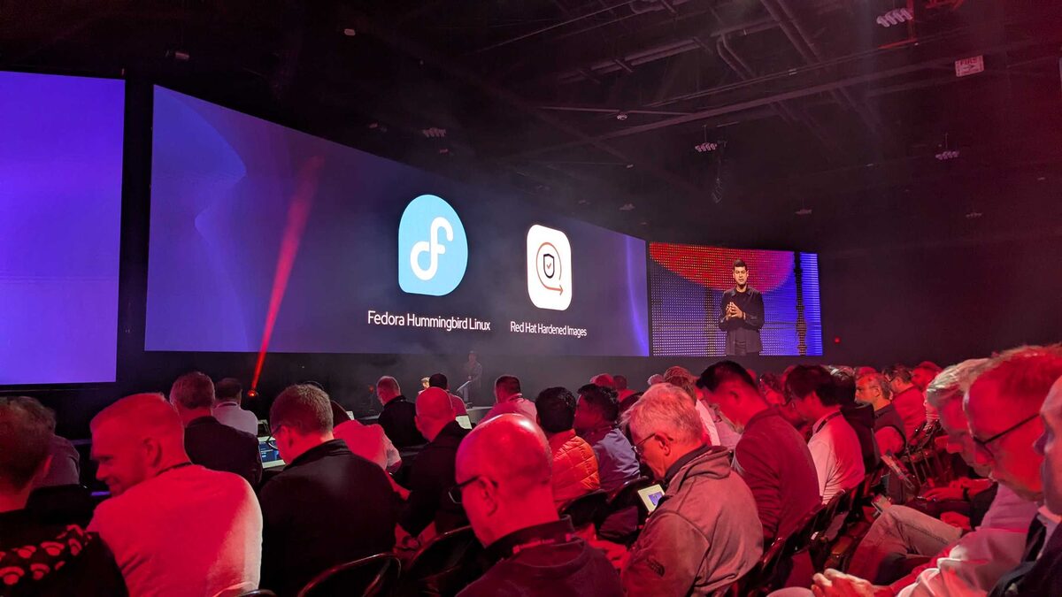 Red Hat Summit 2026 keynote stage with Fedora Hummingbird and Hardened Images announcement