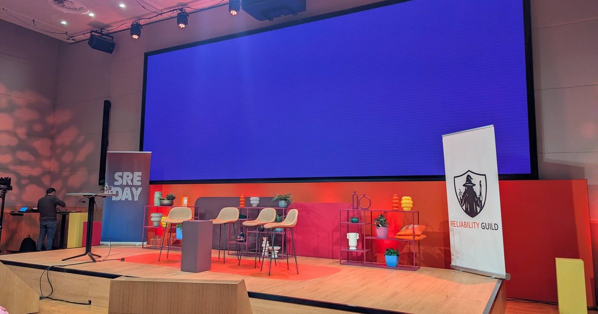 The SREday main stage in Amsterdam before the first talks, with an SRE DAY banner and a Reliability Guild banner next to the screen