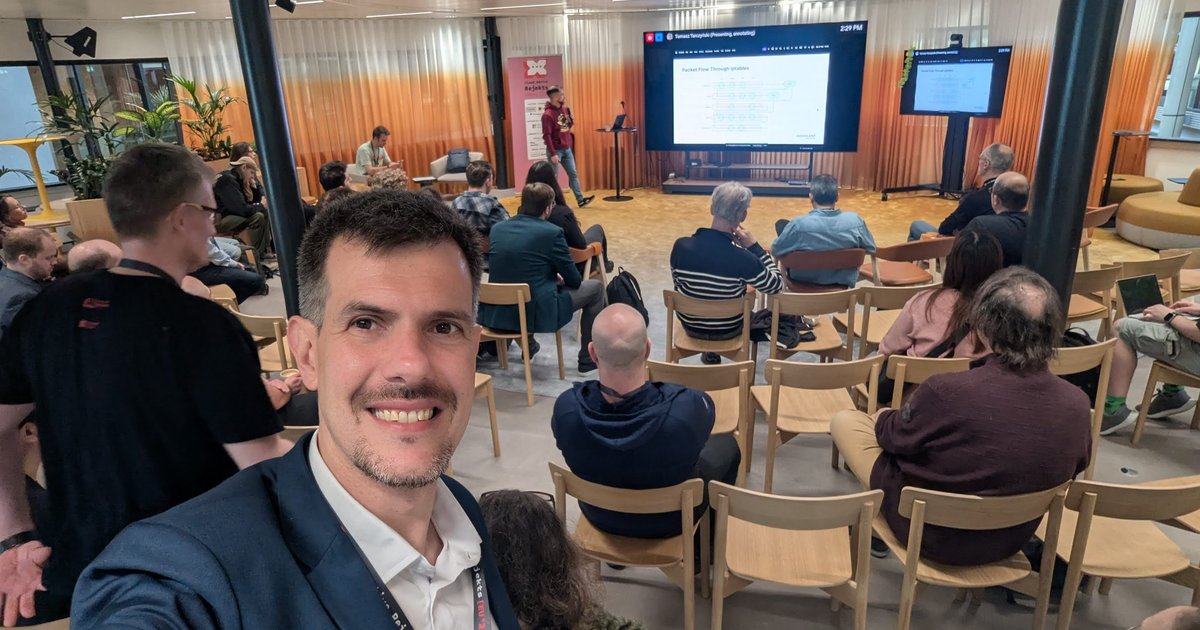 Luca Berton in Room 2 at Cloud Native Rejekts 2026 at Miro HQ in Amsterdam during a Kubernetes networking talk