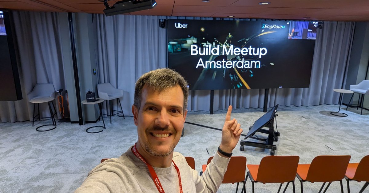 Luca Berton taking a selfie in front of the Build Meetup Amsterdam screen with the Uber and EngFlow logos, before the talks started